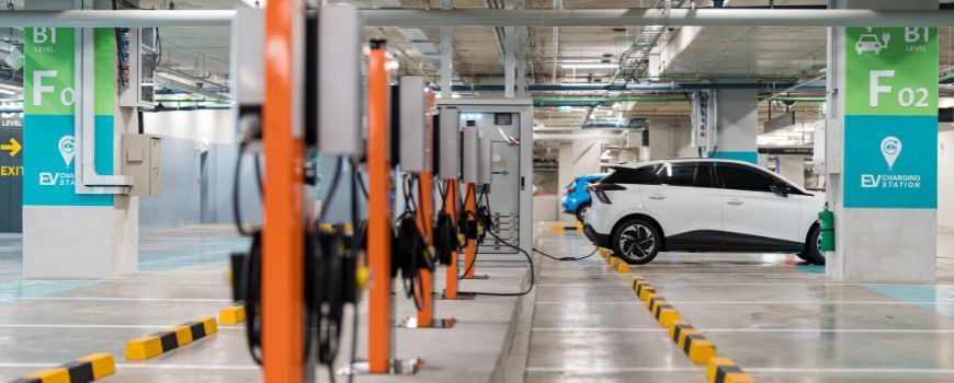 An image of an electric vehicle charging at a public charging station. 